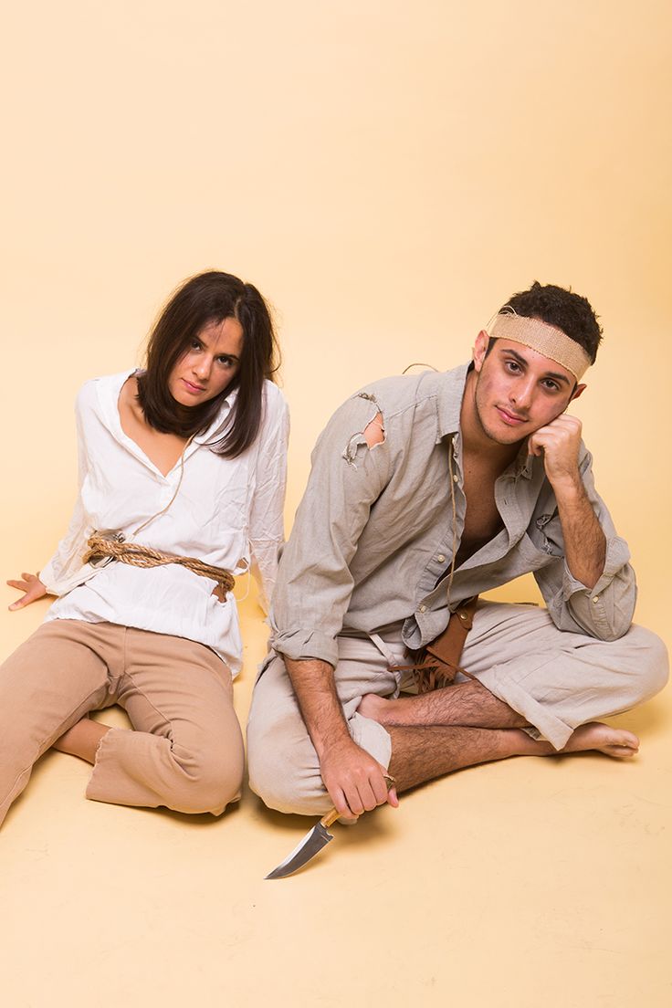 a man and woman sitting on the floor posing for a photo together with headbands around their ears