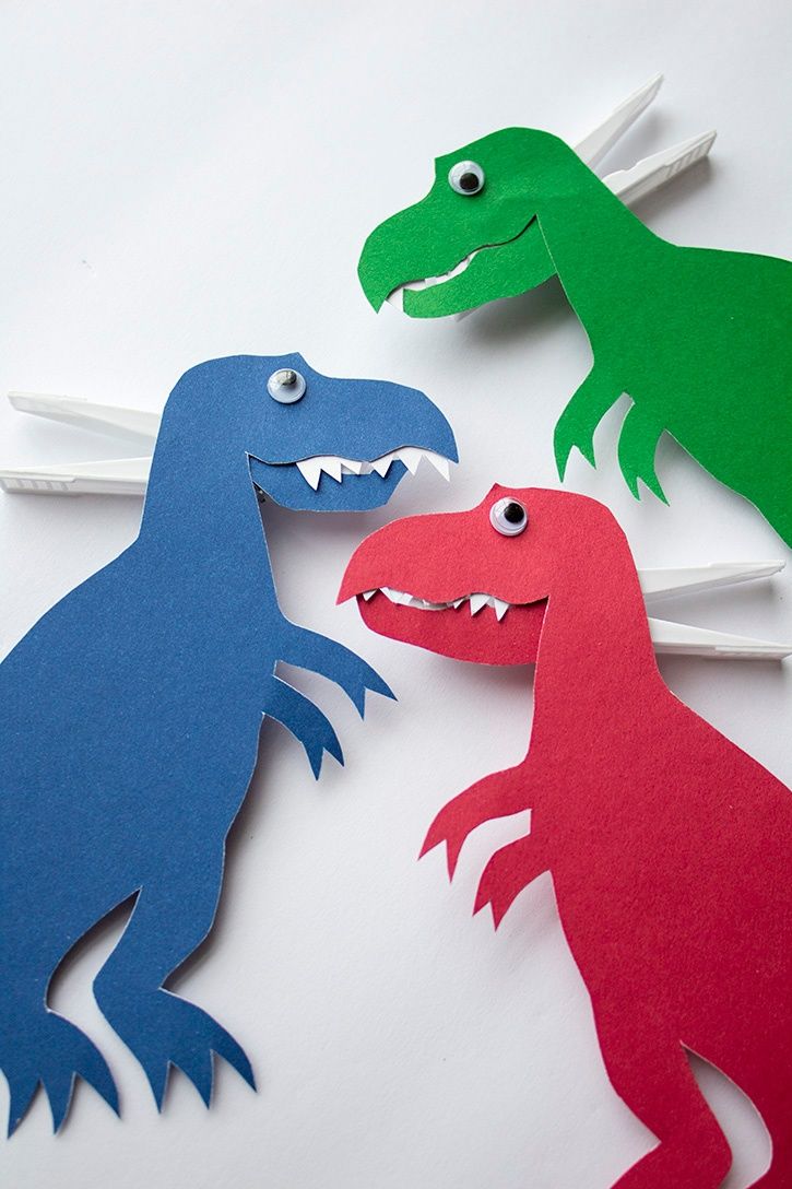 three paper dinosaurs with toothpicks in their mouths