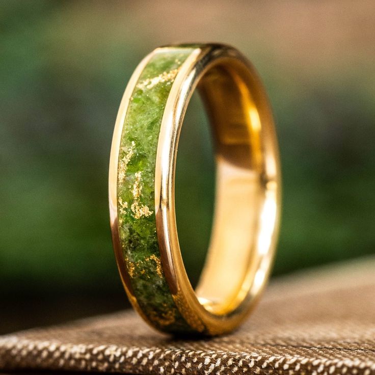 a gold wedding band with green moss inlay