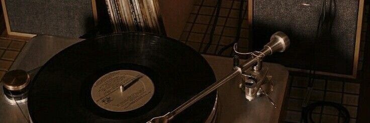 an old record player sitting on top of a table next to a wall mounted clock