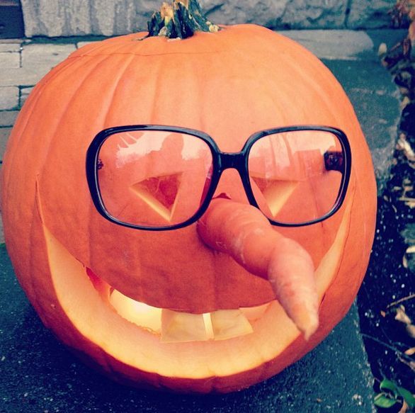 a close up of a pumpkin with glasses on it's face and tongue sticking out