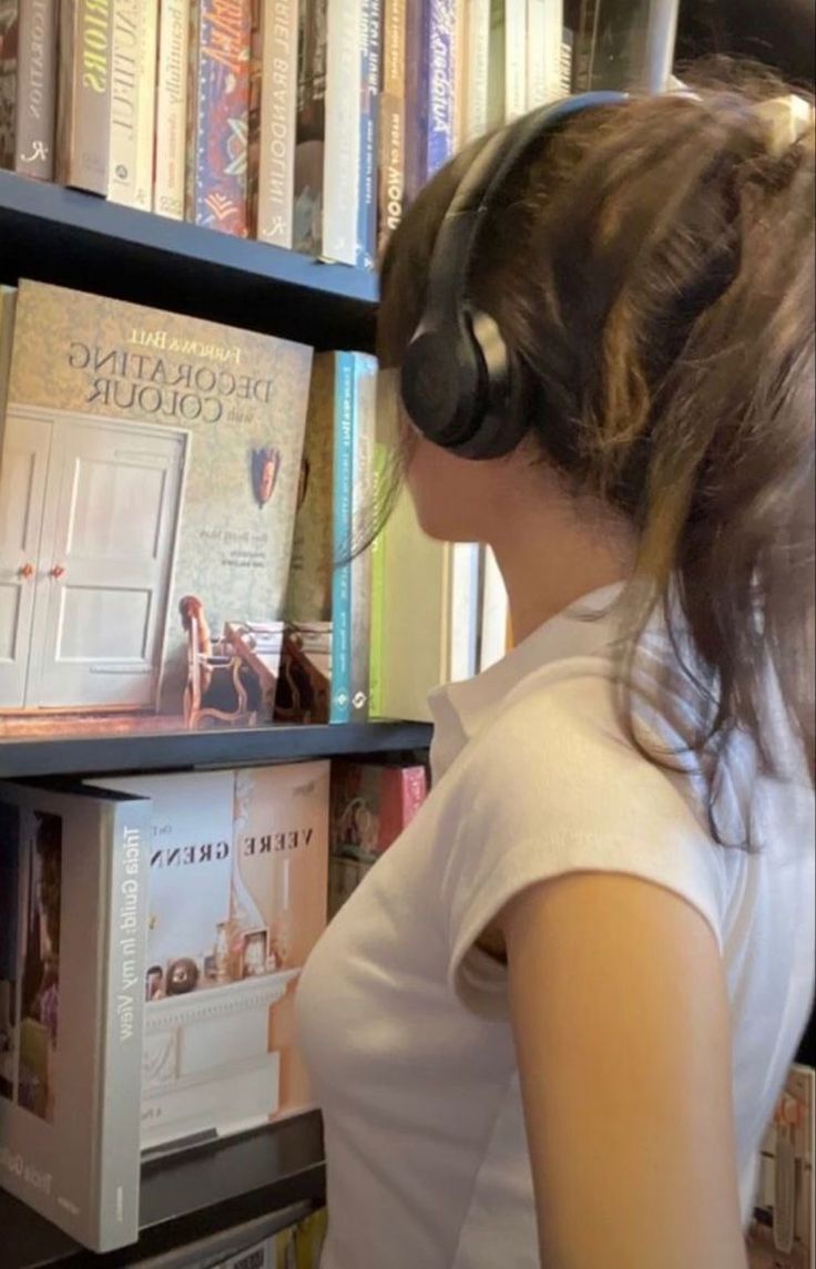 a girl wearing headphones looking at books