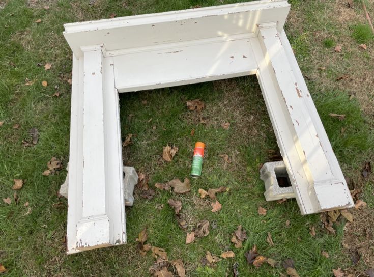 an old white bench sitting in the grass