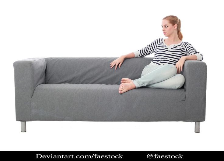 a woman sitting on top of a gray couch