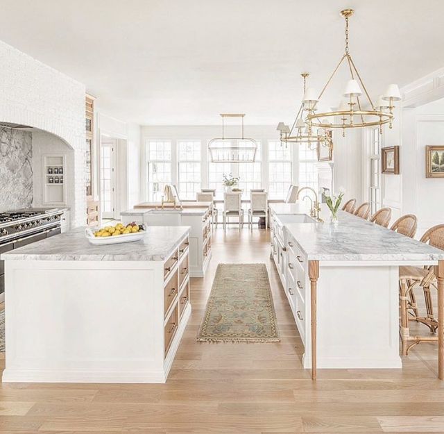 an image of a kitchen setting with marble counter tops and white cabinets in the center