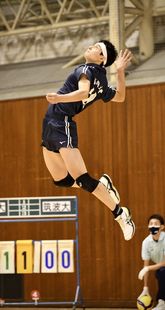 a woman jumping in the air to hit a volleyball