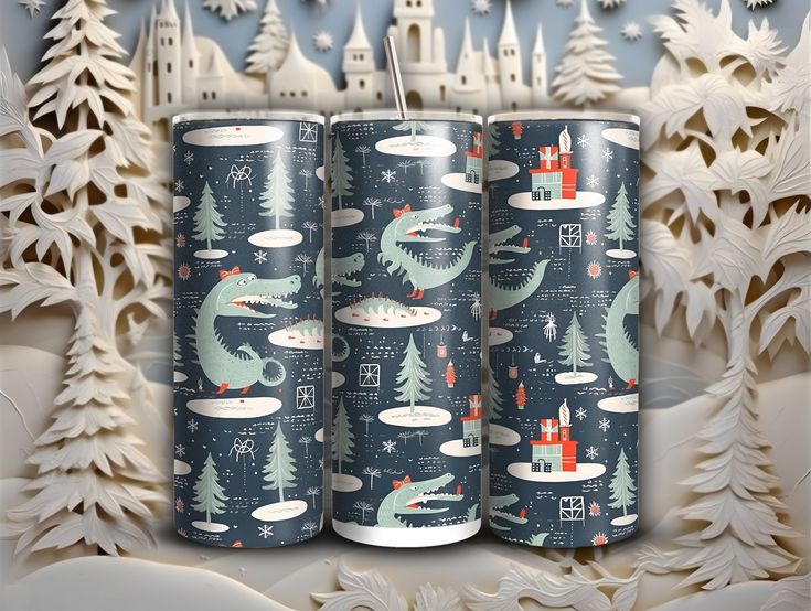 three cans with christmas designs on them sitting in front of snow - covered trees and castle