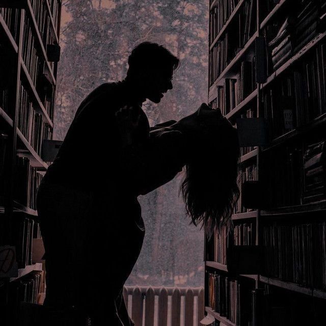 a person standing in front of a bookshelf filled with lots of book shelves