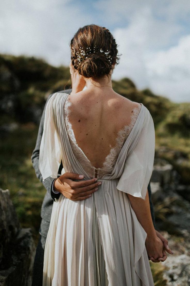 the back of a woman's dress as she stands next to a man