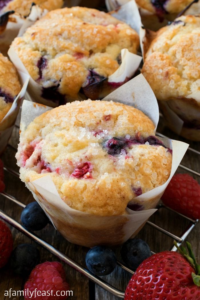 blueberry muffins cooling on a rack with fresh berries