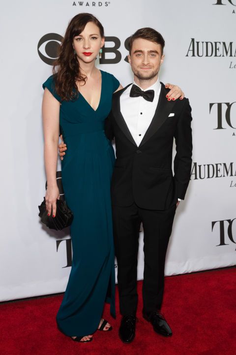 a man in a tuxedo standing next to a woman