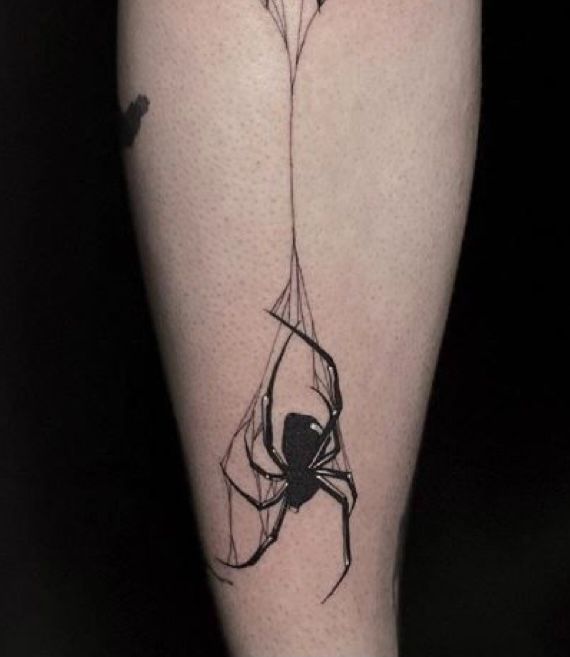 a black and white spider tattoo on the leg