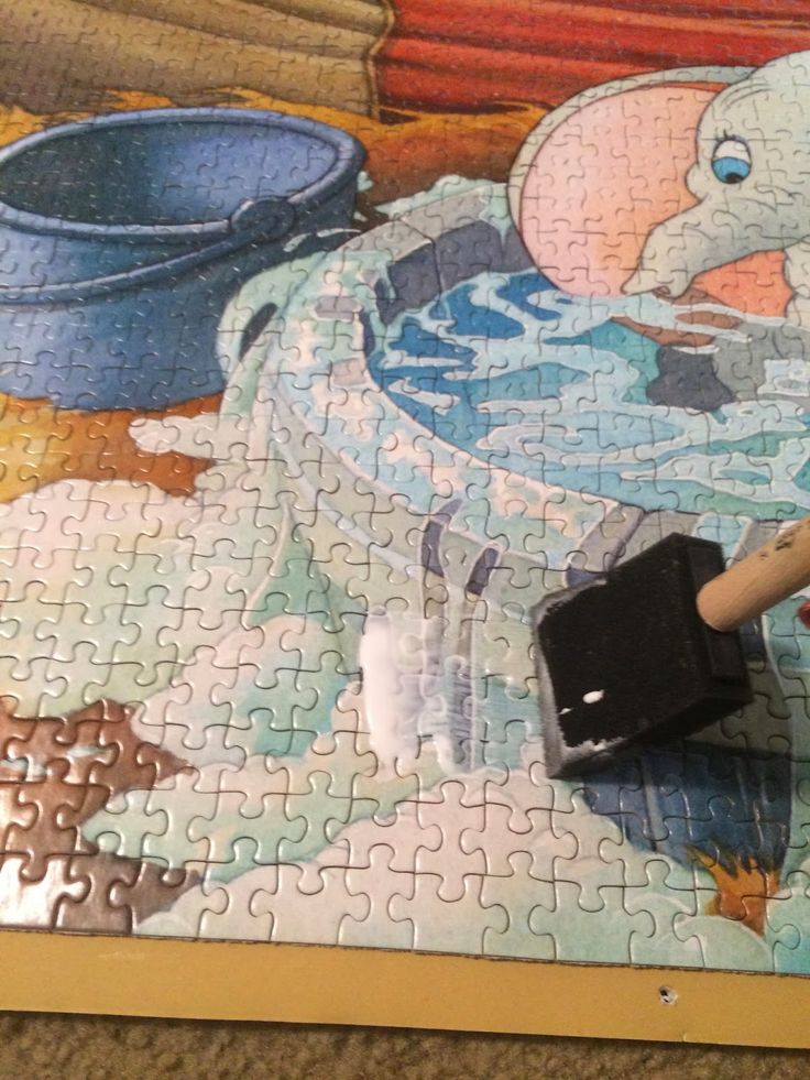 a jigsaw puzzle is laying on the floor next to a piece of artwork