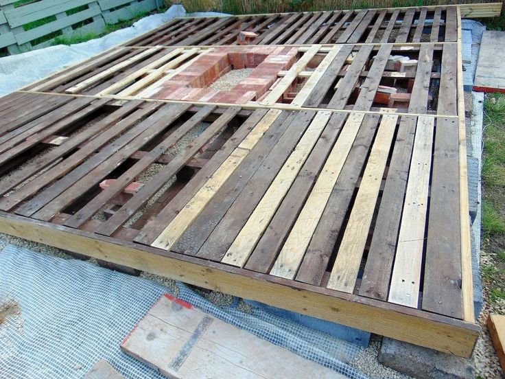 an unfinished wooden deck being built on the ground