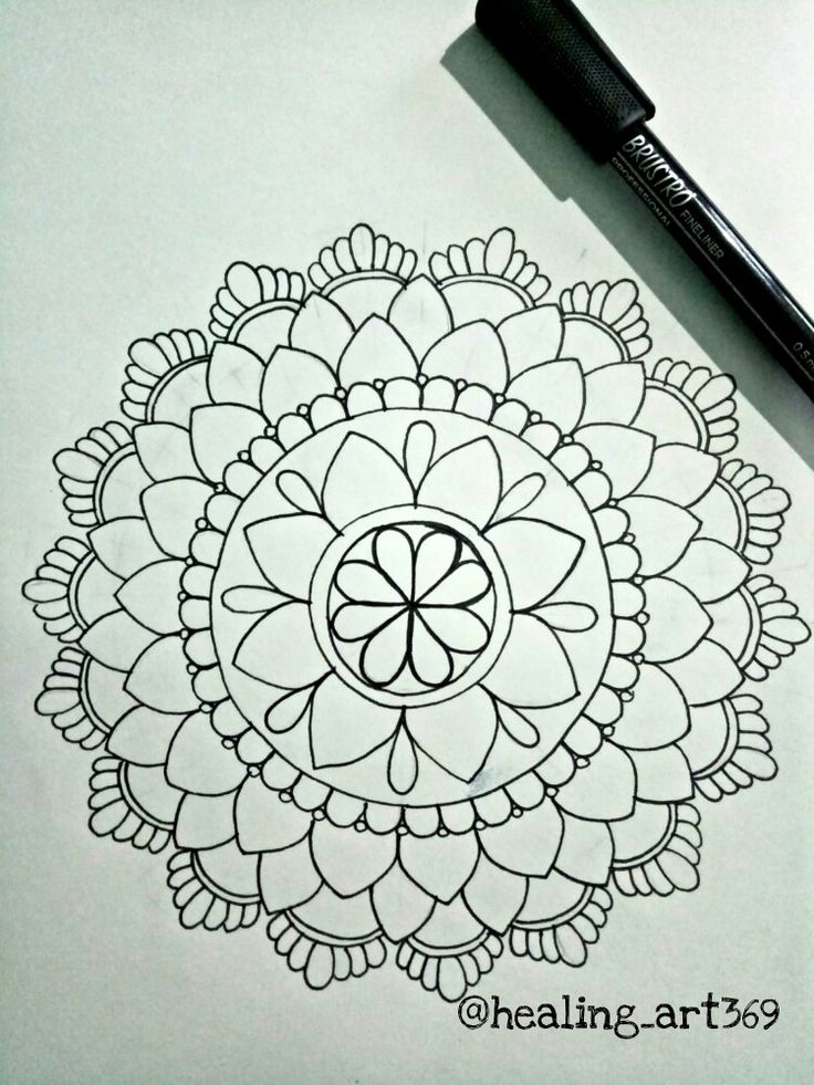 a black and white drawing of a flower on paper with a pen next to it