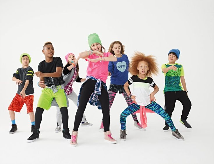 a group of young children standing next to each other in front of a white background