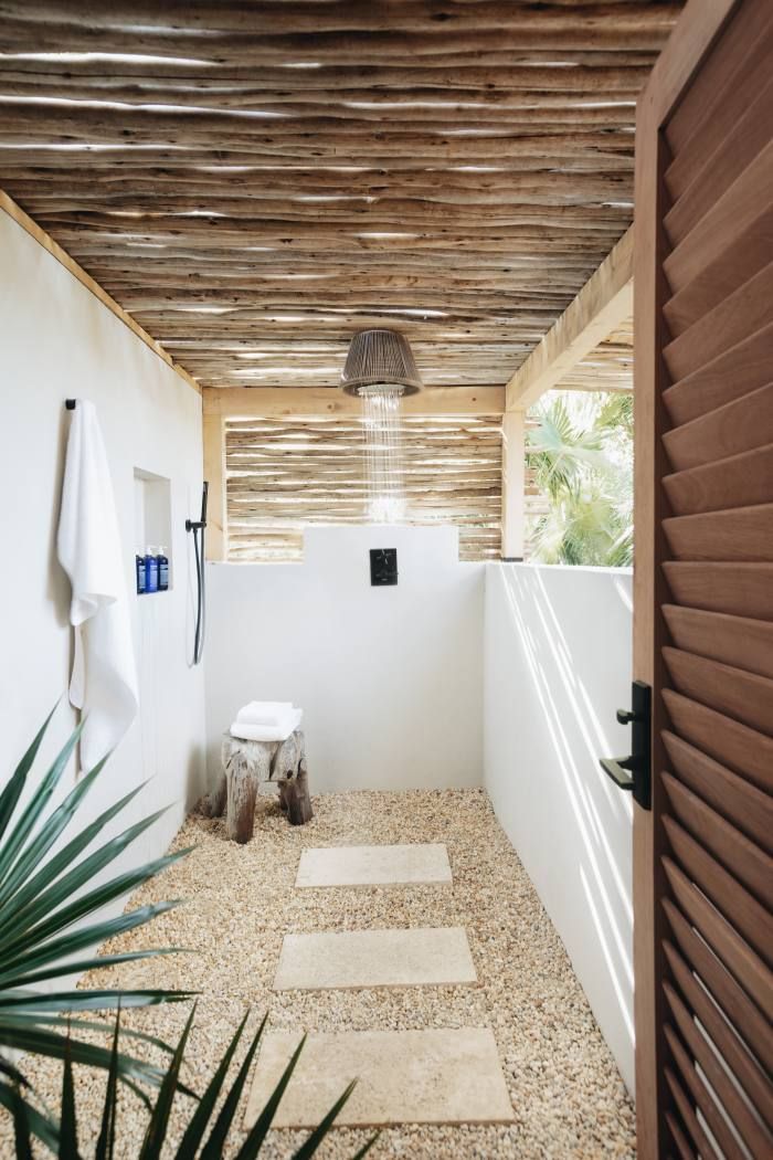 a white bathroom with wood slats on the ceiling and wooden steps leading up to it