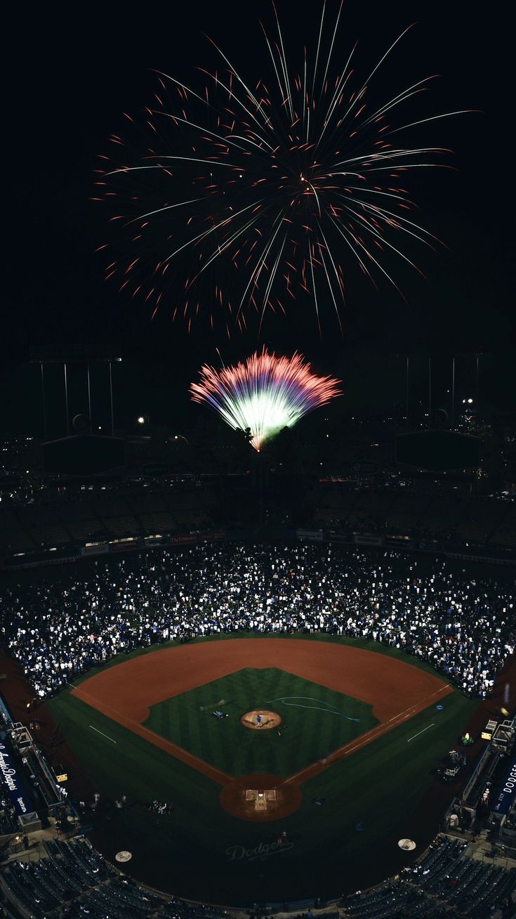 fireworks in the sky above a baseball field