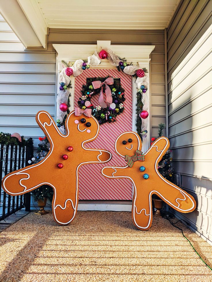 two gingerbread men standing in front of a door