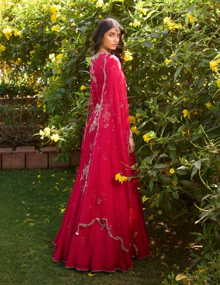 Dazzle in this carmine red chiffon anarkali paired with an exquisite organza cape. Adorned with delicate thread and pearl embroidery, this ensemble exudes timeless elegance and sophistication, perfect for making a statement at any event. Cape Sleeves Anarkali Set With Cutdana For Eid, Anarkali Set With Sheer Dupatta And Cape Sleeves, Anarkali Gown With Cape Sleeves And Resham Embroidery, Red Organza Floor-length Sharara, Wedding Anarkali Set With Cutdana And Cape Sleeves, Cutdana Cape Sleeve Wedding Dress, Anarkali Dress With Dupatta And Cape Sleeves, Elegant Red Sharara With Sheer Dupatta, Organza Dress With Dupatta And Cape Sleeves