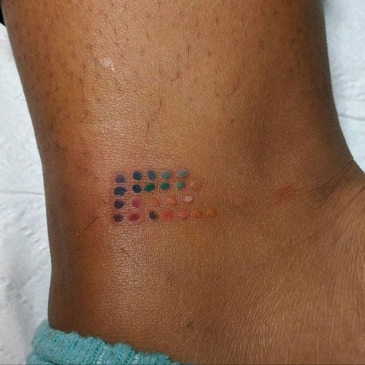 a person with a tattoo on their left side that has colored dots all over it