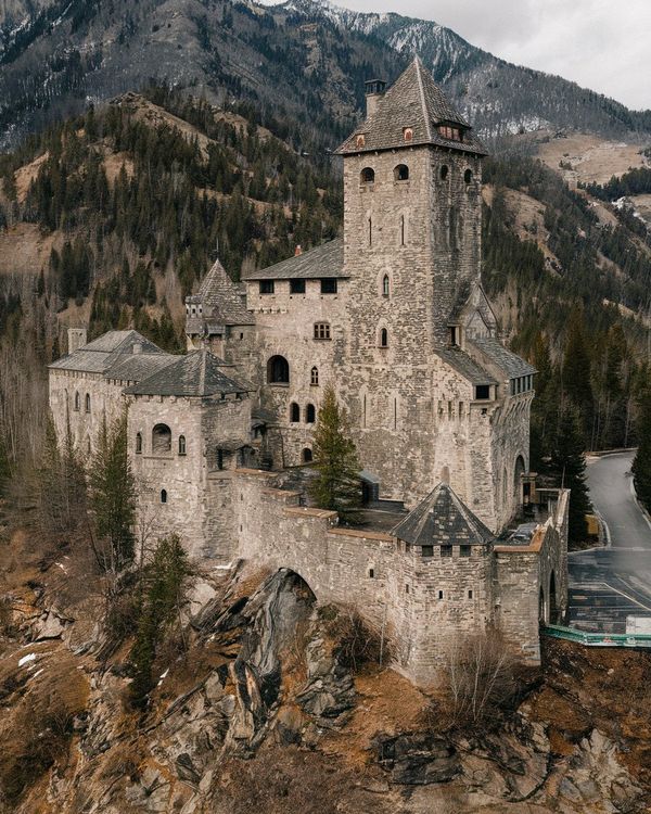 an old castle sits on top of a mountain