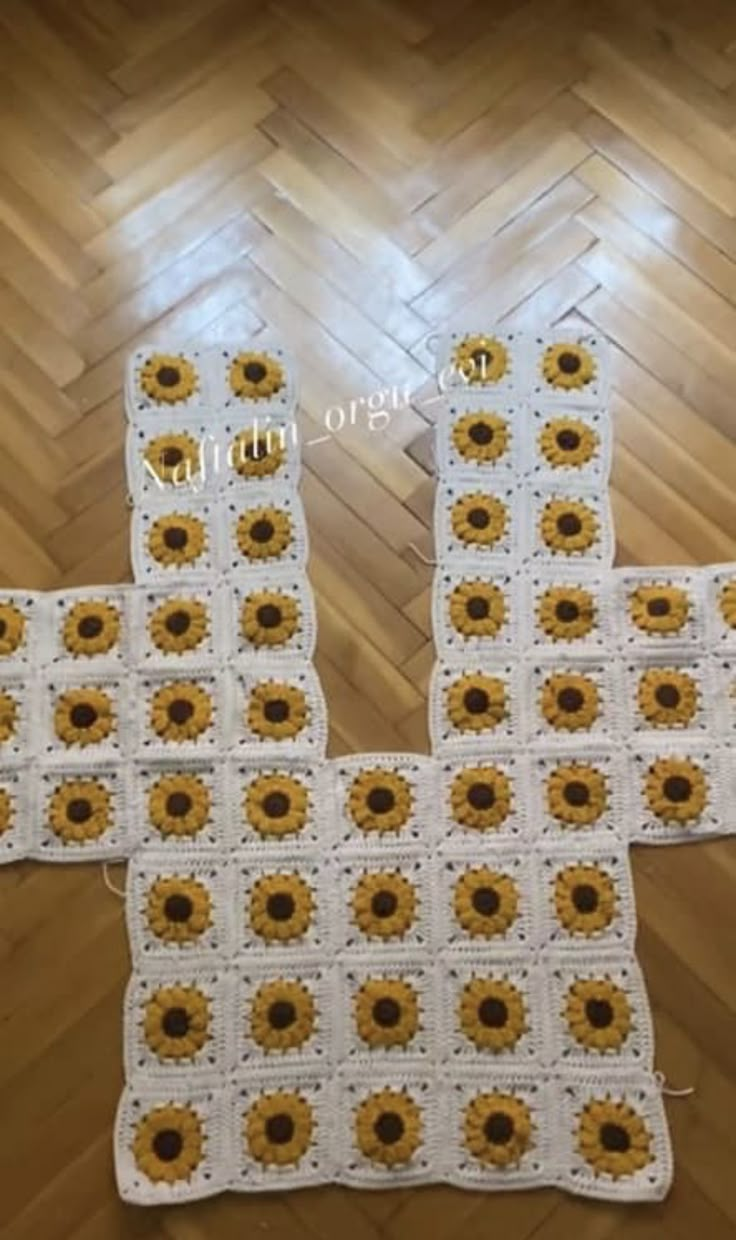 three crocheted sunflowers are sitting on the floor