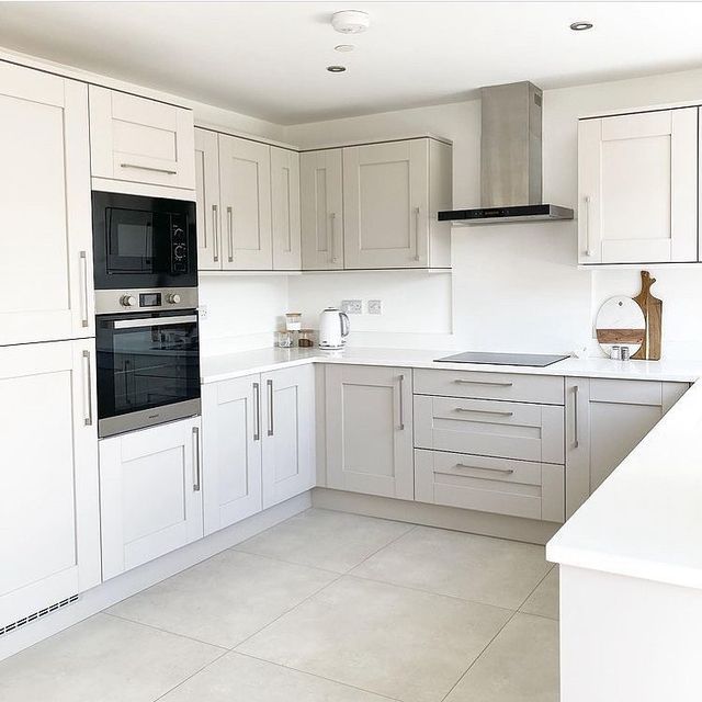 an empty kitchen with white cabinets and black stove top oven, counter tops and drawers