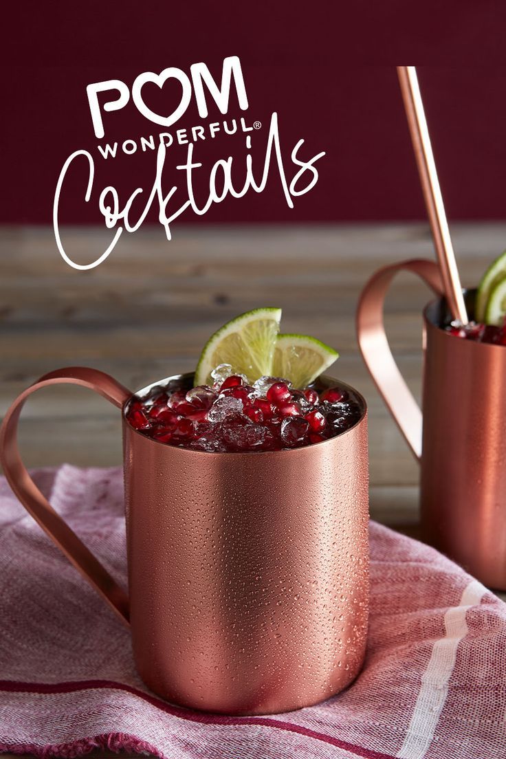 two copper mugs filled with pomegranate and lime