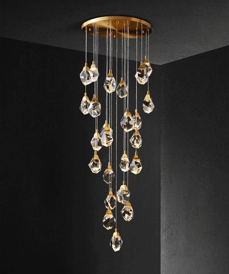 a chandelier with many crystal drops hanging from it's sides in a dark room