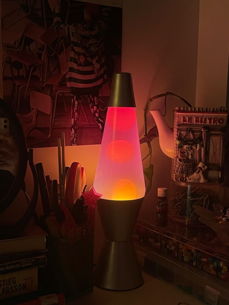 a lamp that is sitting on top of a desk next to books and pencils