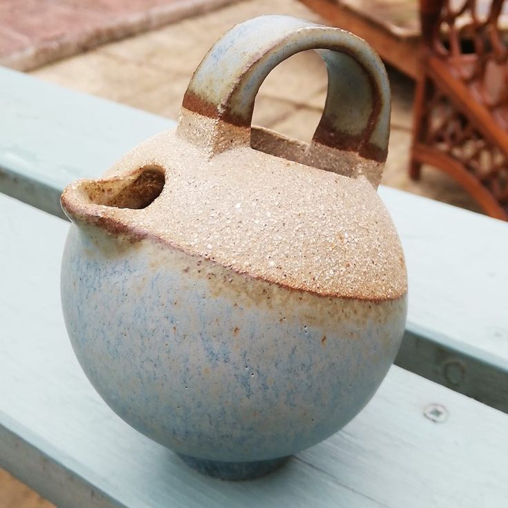 a blue and white vase sitting on top of a wooden bench