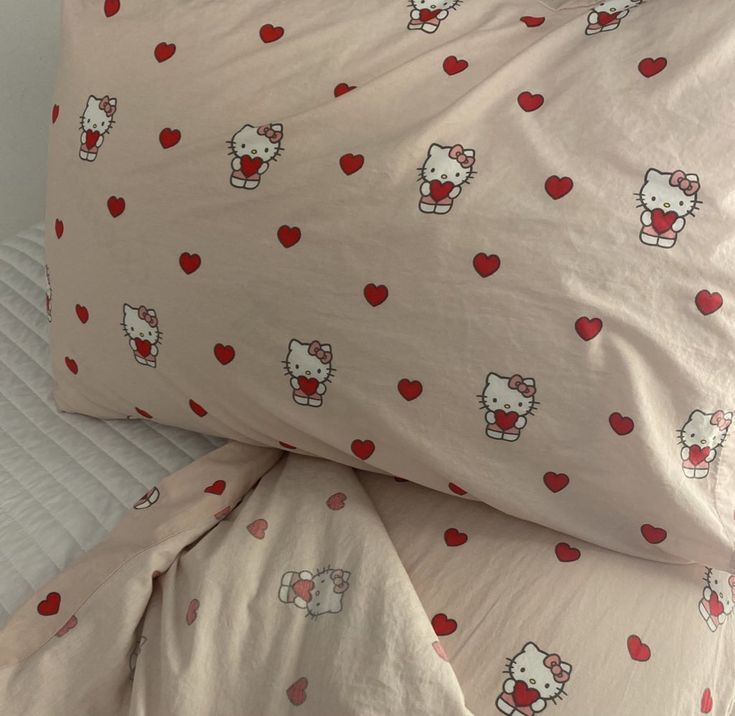 two pillow cases with hello kitty hearts on them, one is pink and the other is white