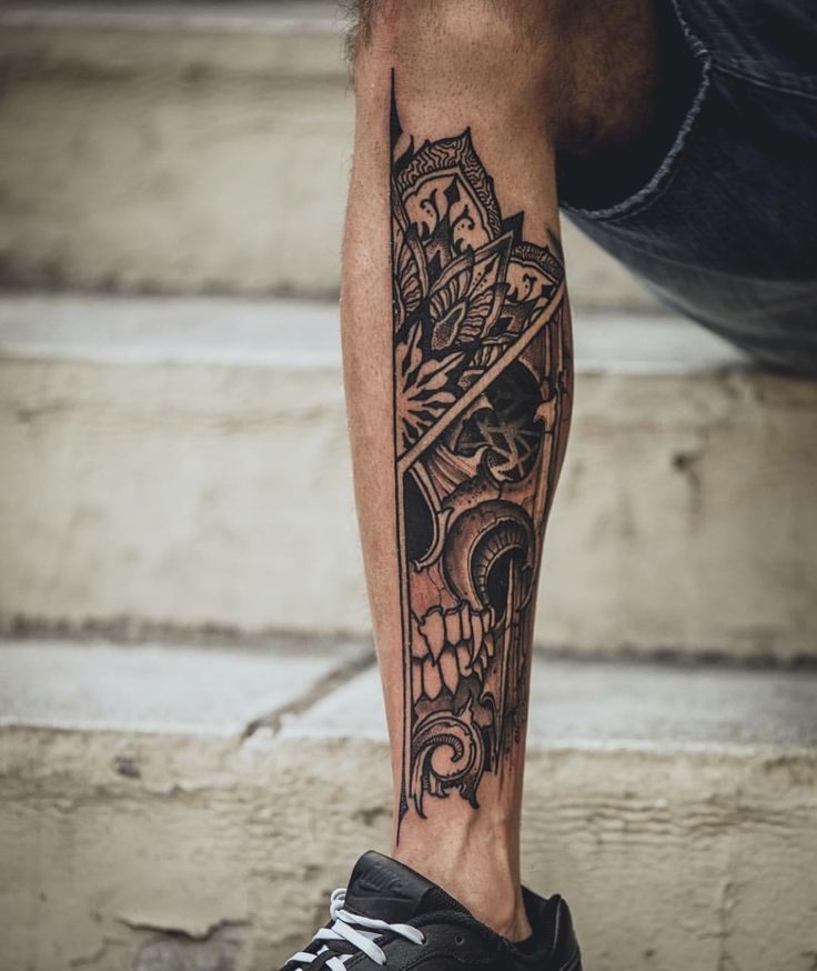 a man's leg with a tattoo on it and a skull in the middle