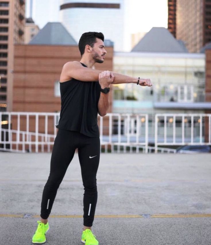 a man in black shirt and leggings pointing at something