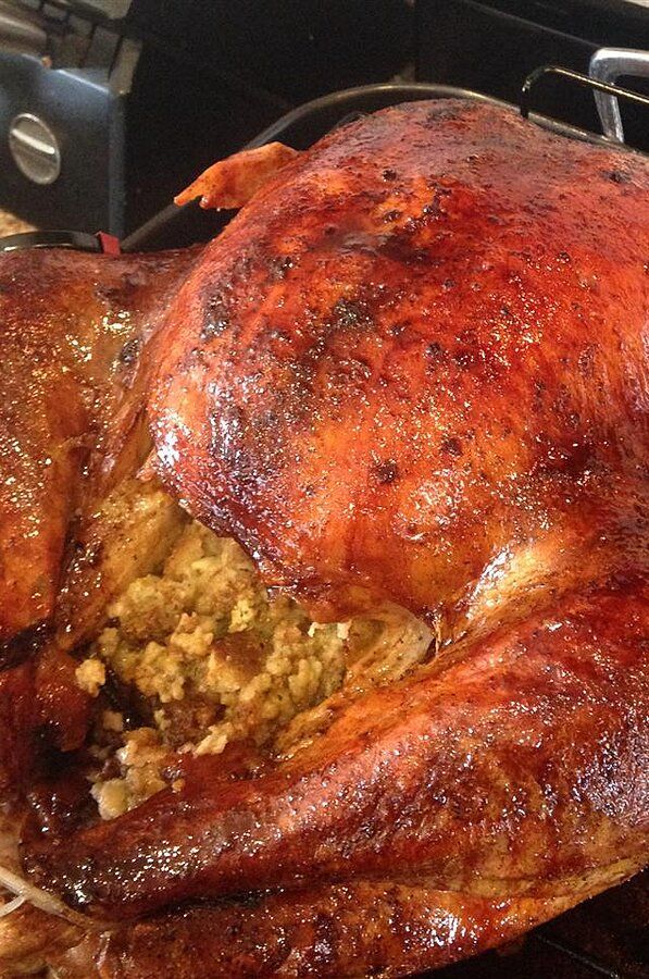 a roasted turkey is being cooked in the oven with other food items on top of it