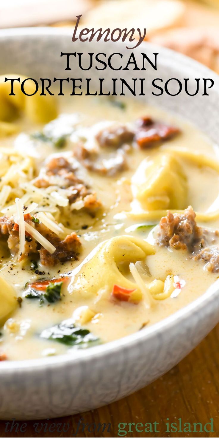 a white bowl filled with tortellini soup on top of a wooden table