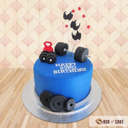 a blue birthday cake with black wheels on it