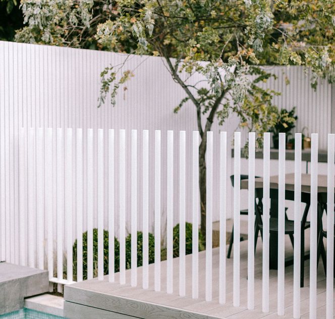 a white fence next to a swimming pool