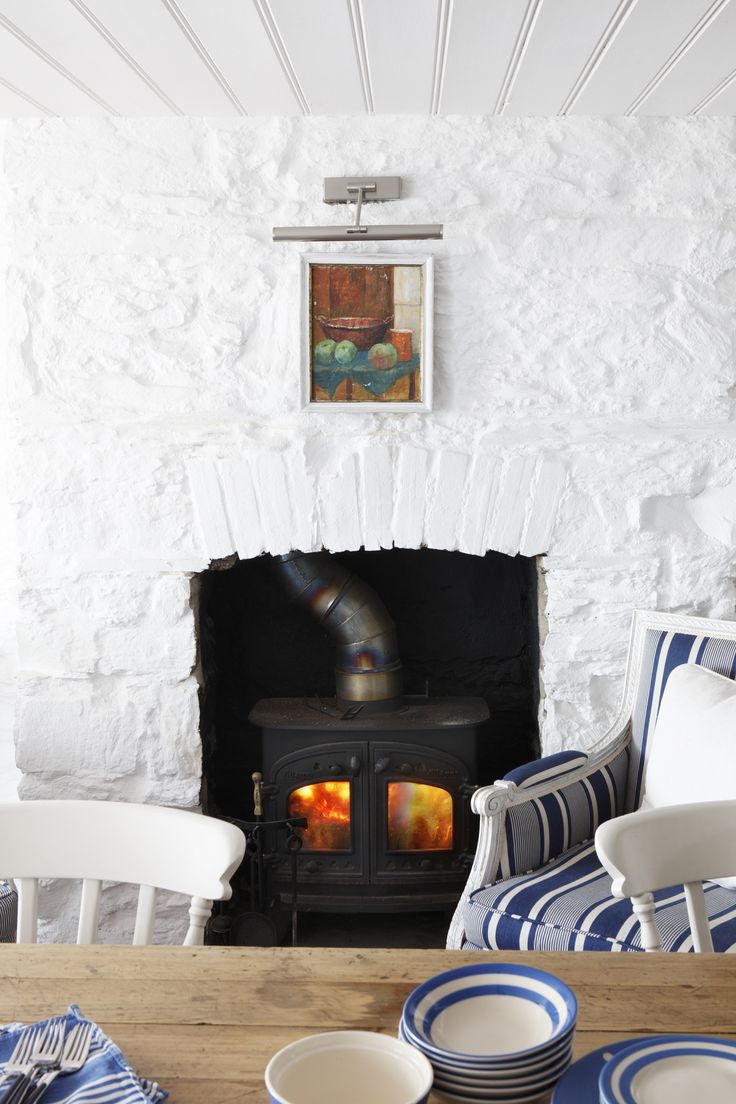 a table with plates and bowls on it in front of a fire place