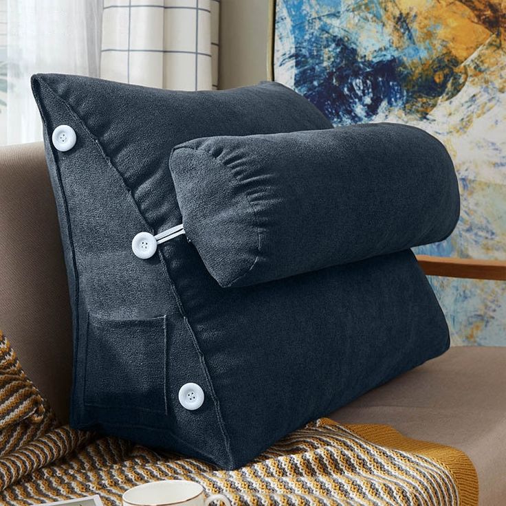 two pillows with buttons on them sitting on a couch