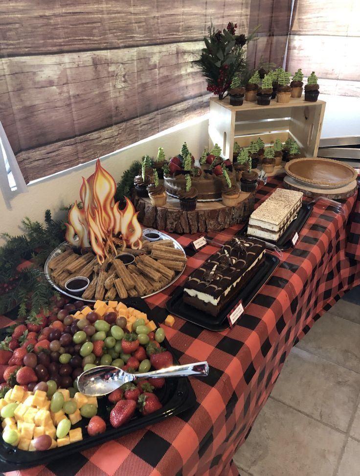 a table topped with lots of food and desserts on top of a checkered table cloth