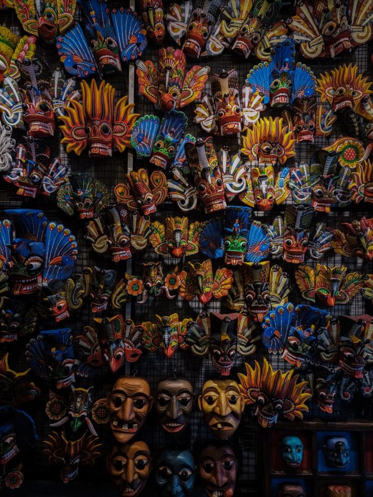 many masks are hanging up on the wall