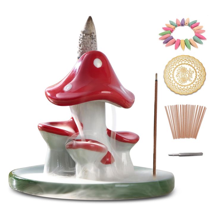 a red and white mushroom sculpture sitting on top of a table next to a stick