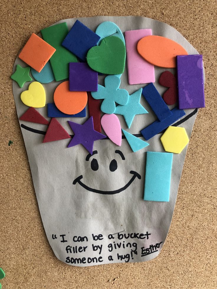 a paper bag that has been made to look like a cup full of colorful shapes