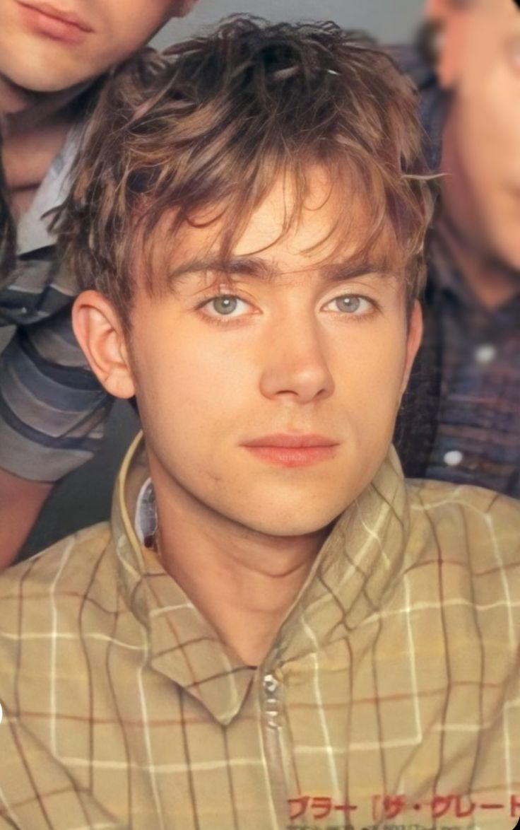 three young men are looking at the camera with one man's head tilted to the side