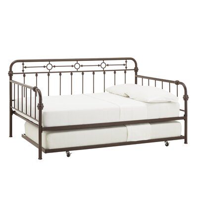 a metal daybed with white sheets and pillows on it's sides, against a white background