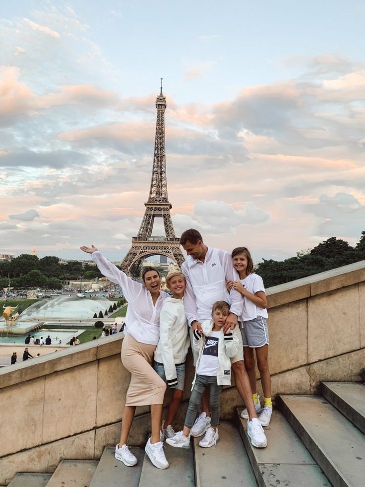 a family poses for a photo in front of the eiffel tower