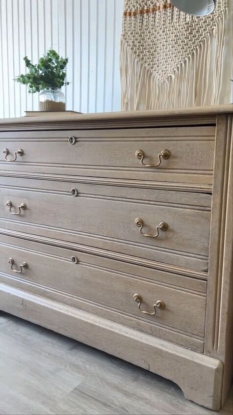 an old dresser is painted white with silver hardware