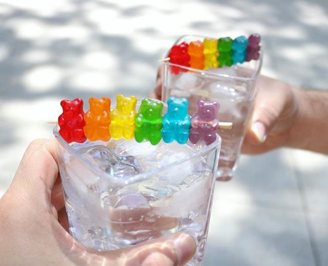 a person holding a glass filled with gummy bears